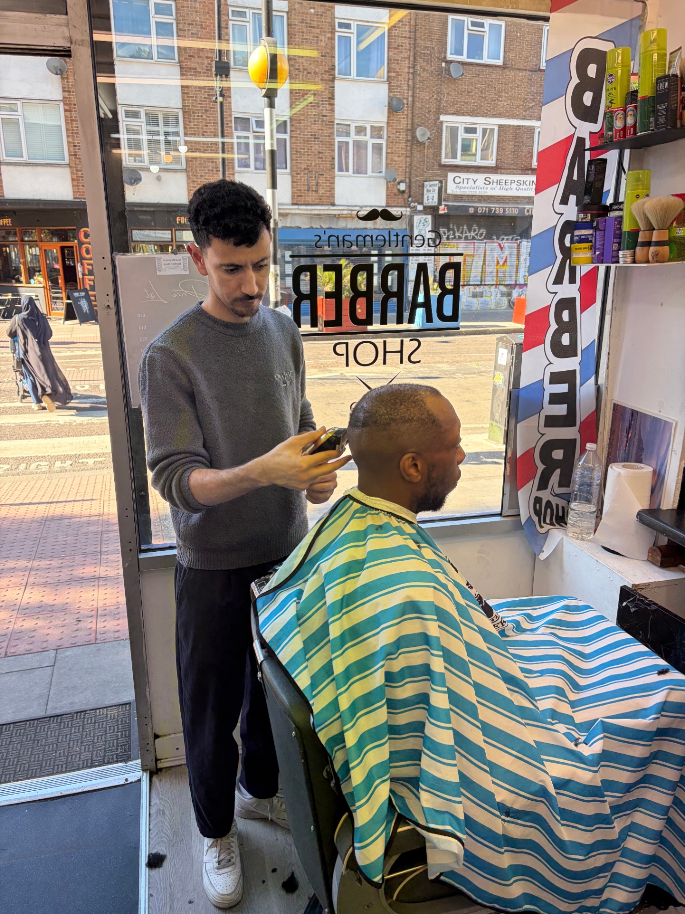 Barber finishing a clean skin fade in the window seat